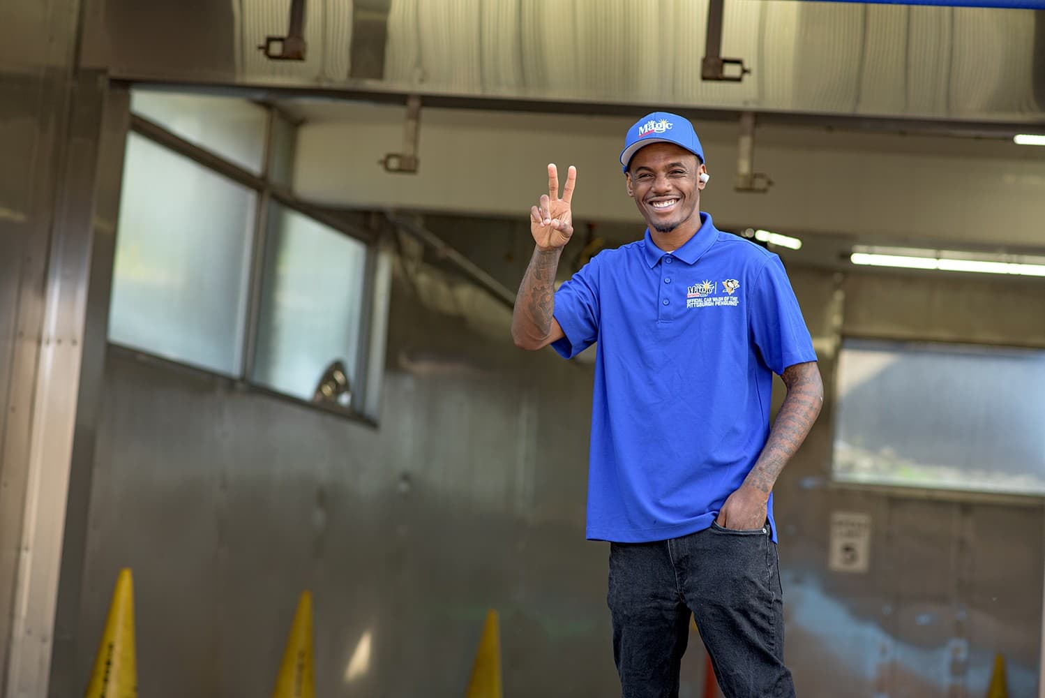 A team member throwing a peace sign inside the wash tunnel