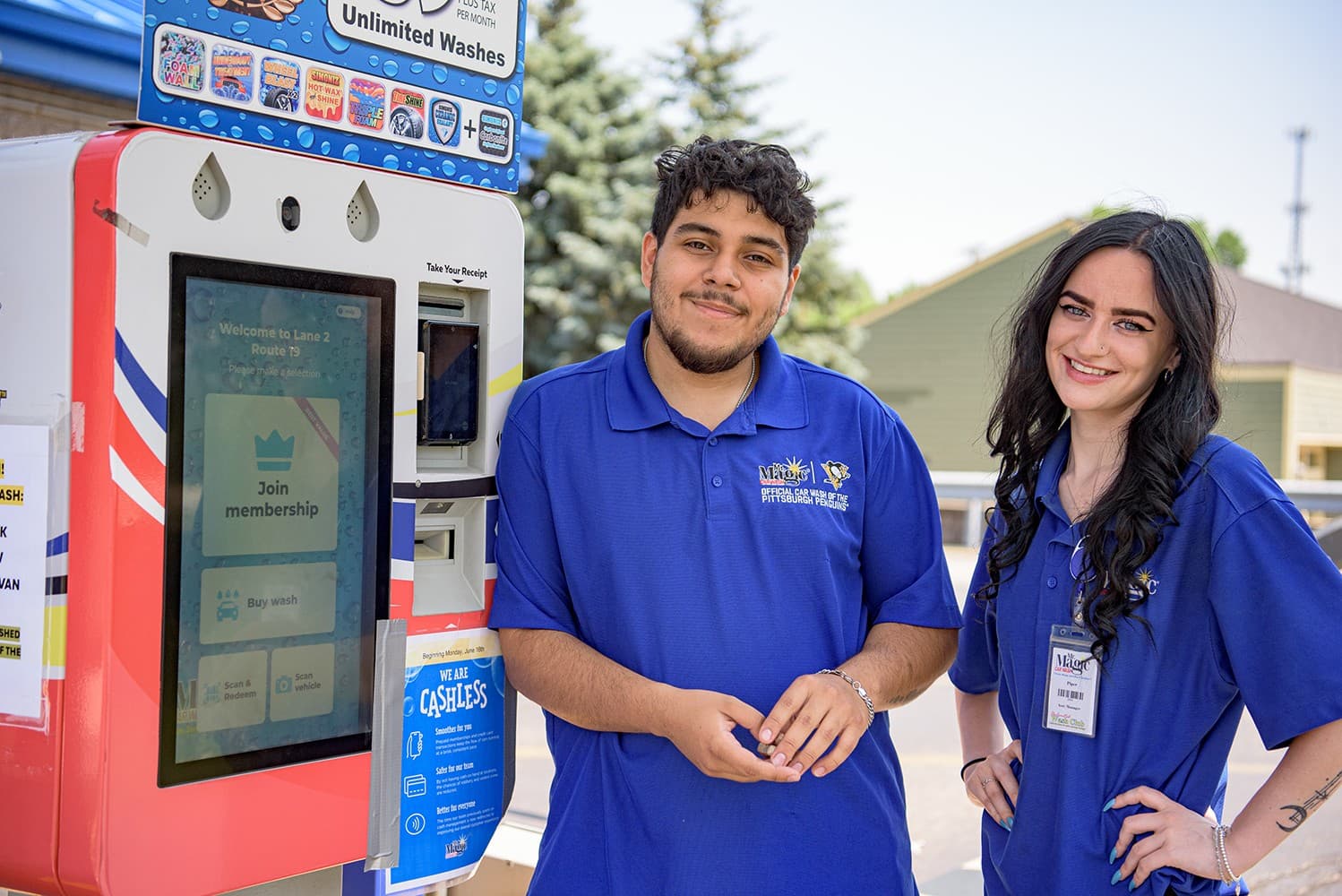 Two Mr. Magic team members next to a pay kiosk