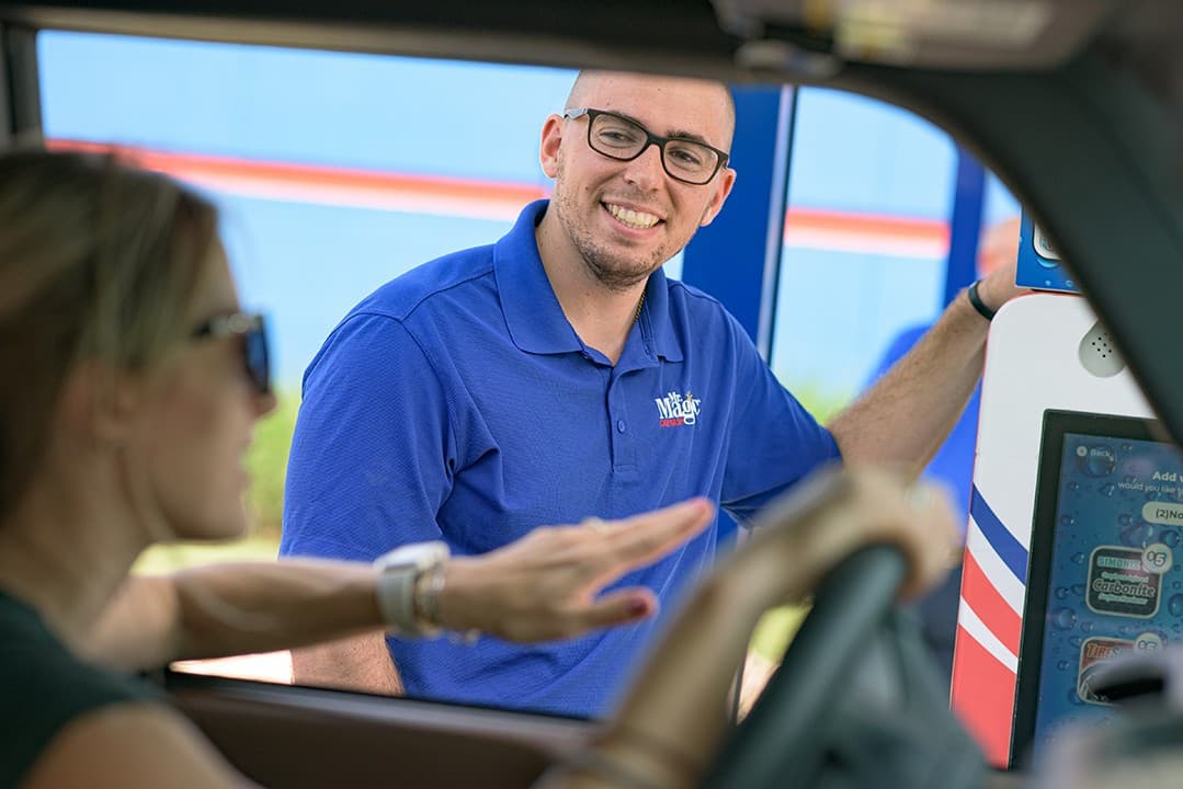 A smiling team member helping a driver