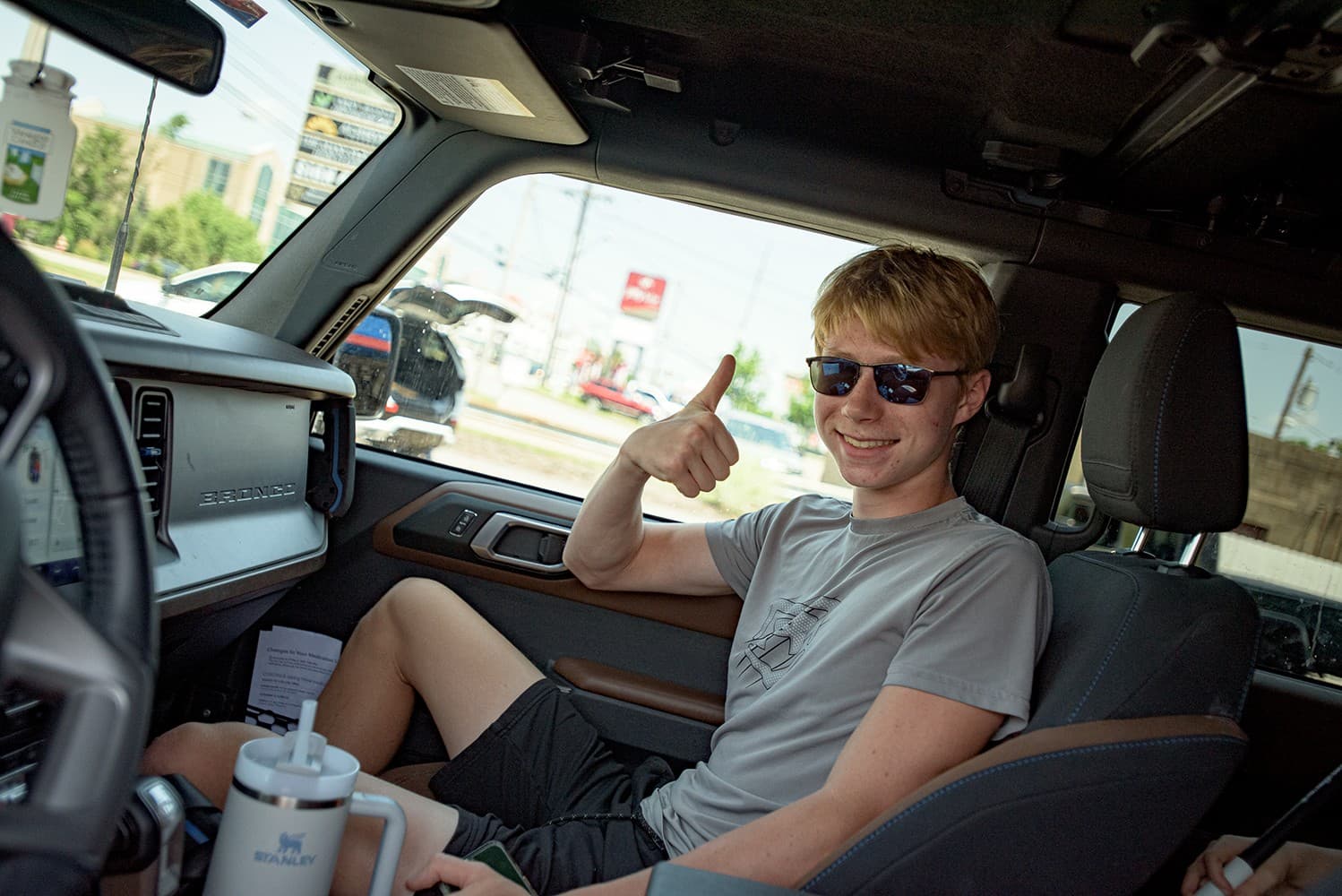 A teen driver giving a thumbs up after the wash