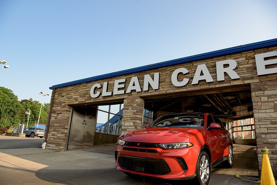 A red car entering the Mr. Magic Clean Car tunnel